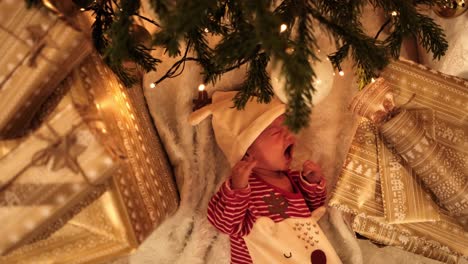 Süßer-Neugeborener-Junge,-Der-Unter-Dem-Weihnachtsbaum-Weint-Und-Entzückende-Rentierkleidung-Trägt