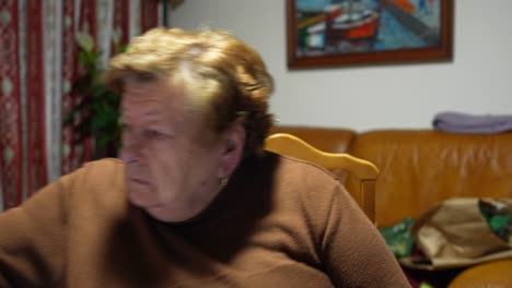 Ältere-Frau-Sieht-In-Einer-Häuslichen-Umgebung-Unzufrieden-Aus-Und-Schlägt-In-Die-Kamera