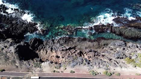 Tenerife-ocean-coast,-blue-water-waves,-volcanic-island-Canary-Islands-drop-down-view