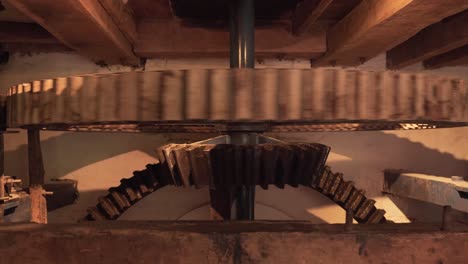 Close-up-on-a-section-of-an-interior-gear-mechanism-of-a-water-mill,-composed-by-two-cogwheels-working-together-to-creat-movement-to-grind-cereals-into-flour