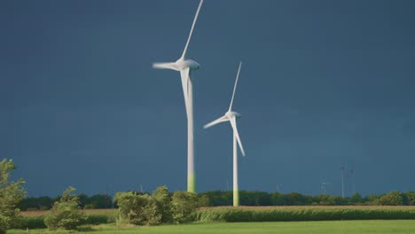 Zwei-Rotierende-Windturbinentürme-über-Der-Grünen-Landschaft
