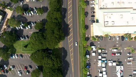 Roads-and-parking-lots-by-ocean-in-Lahaina,-Hawaii,-aerial-reveal-tilt