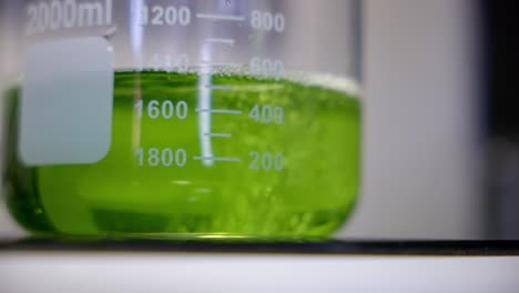 Close-up-of-a-pouring-green-liquid-for-test-in-laboratory