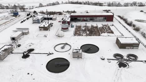 Water-treatment-facility-covered-in-snow-in-arctic-winter-landscape-,-aerial-establish