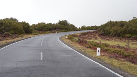 Vista-De-Una-Carretera-En-Las-Montañas-De-La-Isla-De-Madeira-Durante-El-Invierno,-Niebla-Que-Cubre-Una-Sección-De-La-Carretera
