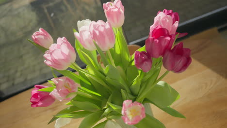 Leuchtende-Tulpen-Sonnen-Sich-Im-Sonnenlicht-Auf-Einem-Holztisch