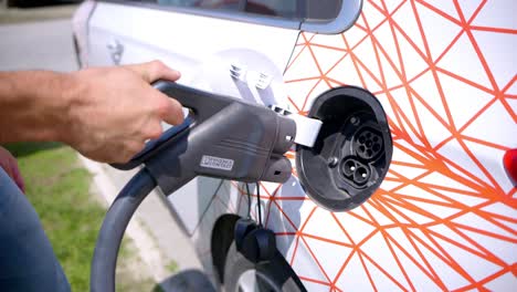 A-person-puts-a-charger-in-an-electric-car