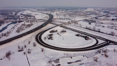 Luftaufnahme-Einer-Schneebedeckten-Autobahn-Und-Ausfahrtskreuzung-Im-Winter