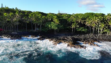 Rotierende-Ansicht-Eines-Hawaii-Inselstrandes-Und-Der-Wellen-Mit-Einigen-Autos-Auf-Der-Einzelnen-Straße,-Die-Zwischen-Den-Bäumen-Kaum-Sichtbar-Ist