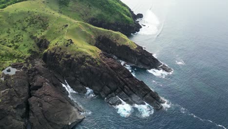 Overhead-aerial-view-of-picturesque-mountainous-rocky-hills-facing-the-ocean-coast-in-Baras,-Catanduanes