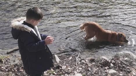 Ein-Kind-Und-Sein-Hund-Im-Fluss