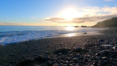 Idyllische-Strandwellen-Auf-Kieselsteinen-Zur-Goldenen-Stunde-Und-Sonnenuntergang,-Kupferküste,-Waterford,-Irland,-Naturschönheit