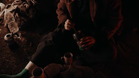 Campfire-Coffee:-Broke-homeless-guy-with-his-leg-in-a-cast-gathering-the-last-coffee-grounds-in-his-can