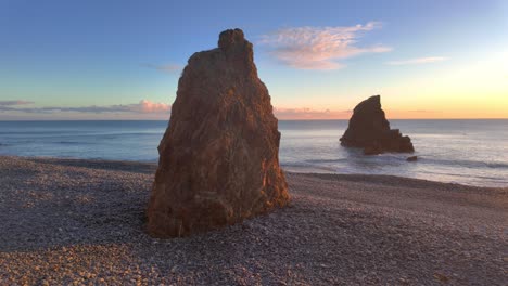 Golden-hour-sea-stacks-in-late-evening-sunshine-on-pebble-beach-with-calm-seas-Copper-Coast-Waterford-Ireland