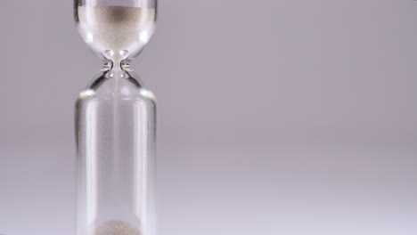 White-sand-running-through-bulbs-of-an-hourglass