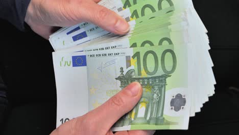 Woman-counting-one-hundred-euro-bills-in-her-hands