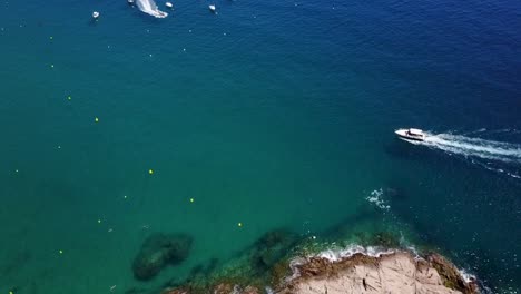 Flying-above-a-sailing-boat-next-to-the-rocky-coast-of-the-Mediterranean-Sea