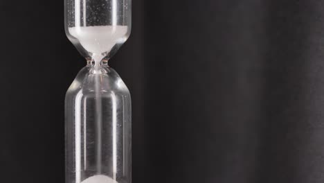 White-sand-running-through-bulbs-of-an-hourglass