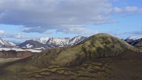 Aerial-drone-ascending-view-in-front-of-the-Norðurnámshraun-lava-field-in-Landmannalaugar,-with-a-small-mountain-in-the-foreground