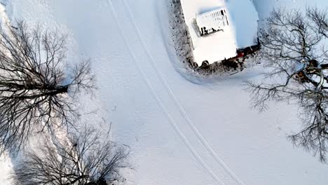 aerial-looking-down-on-old-homestead-in-snow-near-boone-nc,-north-carolina