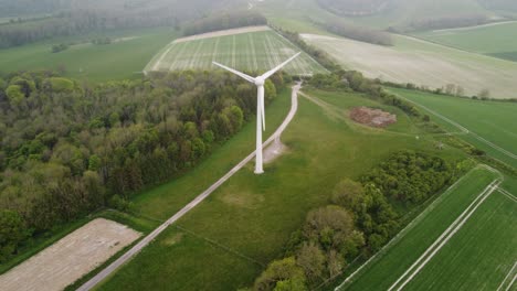 Drone-shot-of-a-wind-turbine-in-the-countryside---South-Downs,-England