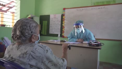 Mujer-Adulta-Mayor-Durante-Una-Consulta-Clínica-En-Una-Brigada-Médica-En-Una-Escuela-De-Una-Comunidad-Pobre-En-Honduras