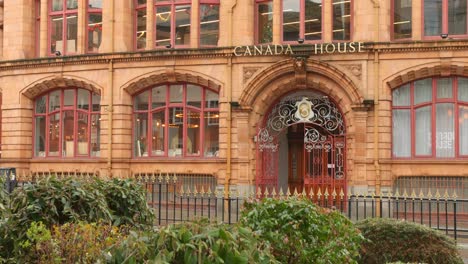 Profile-view-of-the-architecture-of-entrance-of-Canada-House-with-vehicles-passing-by-in-front-of-it-in-Manchester,-England