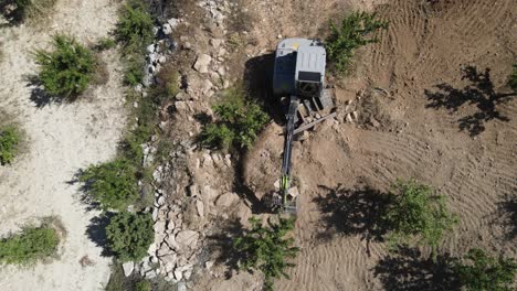 Construction-machinery-working-next-to-the-garden,-drone-shot