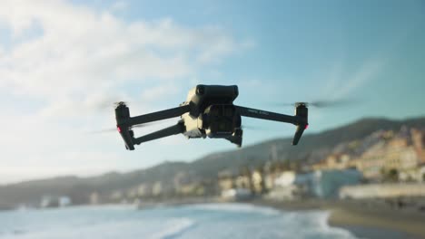 DJI-Mavic-3-Pro-Hovering-In-Mid-Air-With-Bokeh-Beach-Coastline-Background