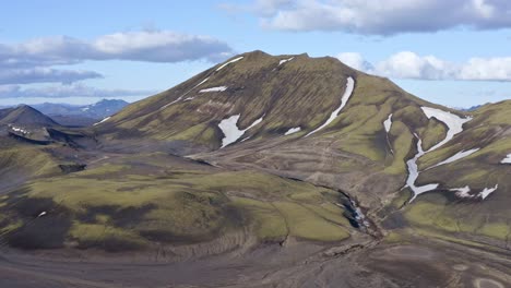 Forward-drone-view-towards-a-green-mountain-near-Bláhylur-Lake-in-Landmannalaugar,-iceland