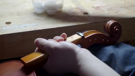 Maestro-Artesano-Luthier-Fabricante-De-Violines-Anticuado-Rizo-De-Violín-Y-Caja-De-Clavijas-Con-Tela-Y-Aceite-Cáustico-ácido-En-Un-Nuevo-Instrumento-De-Cuerda-Para-Reproducir-La-Angustia-De-La-Obra-Maestra-Original