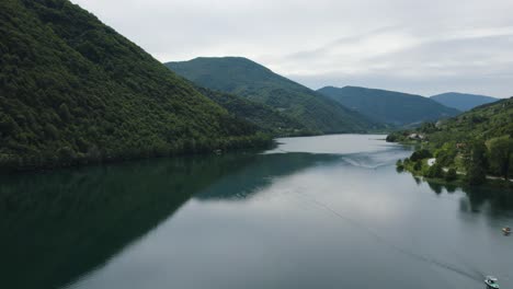 Aerial-forward-scenic-panorama-view-of-lake-Veliko-Plivsko-Jajce,-road-with-cars