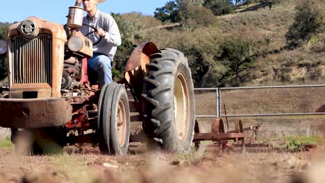 Viehzüchter-Fährt-Traktor-Mit-Egge-Und-Pflügt-Feldgestell,-Fokus-Auf-Traktor