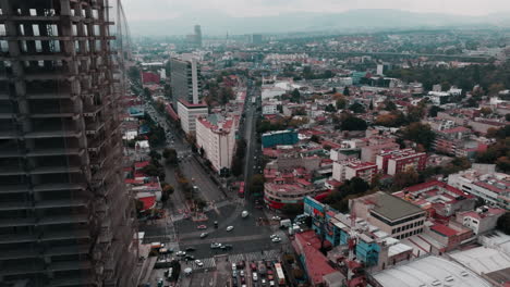 Drone-footage-of-Mexico-City-showcasing-highways,-streets,-cars,-homes,-and-distant-mountains-against-the-skyline