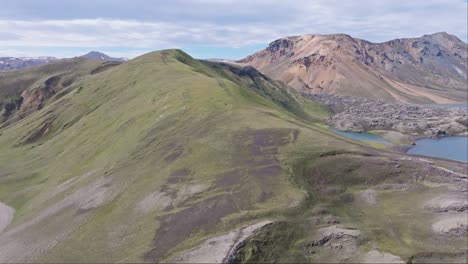 Aerial-forward-drone-view-of-the-hiking-path-on-the-left-of-Frostastaðavatn-Lake-in-Landmannalaugar,-heading-towards-the-lava-flow