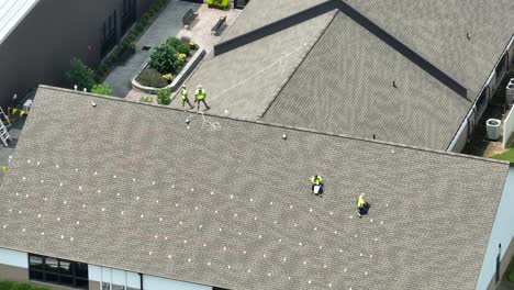 Men-working-on-shingle-roof-installing-mounting-devices-for-solar-panels