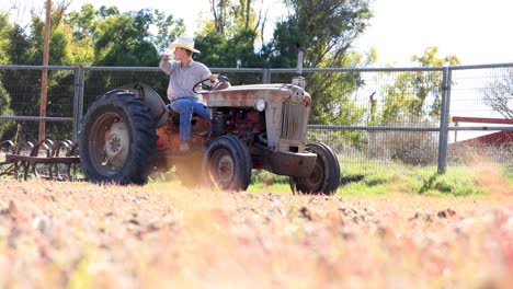 Cowboy-Looking-Over-the-Land-on-Tractor-Harrowing-Pasture