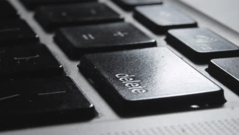 Close-up-of-Finger-Pressing-"Delete"-Key-on-Laptop-Keyboard