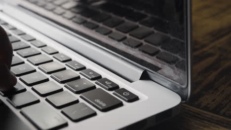 Ecke-Der-Laptop-Tastatur-Mit-Teilweise-Sichtbaren-Fingern-Beim-Tippen
