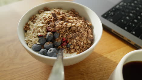 Lunchbreak-with-Healthy-breakfast-bowl-with-granola,-blueberries,-and-a-side-of-coffee-and-laptop