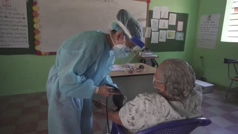 Eine-Ärztin-Untersucht-Eine-ältere-Frau-Mit-Einem-Blutdruckmessgerät-Und-Einem-Stethoskop-Während-Einer-Medizinischen-Brigade-In-Einer-Armen-Gemeinde-In-Honduras