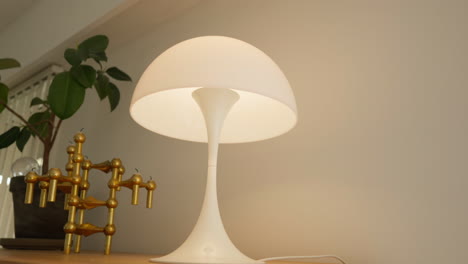 Modern-white-lamp-with-a-golden-structure-on-a-wooden-shelf
