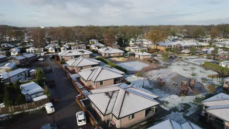 Low-rise-neighborhood-in-the-Netherlands,-aerial-orbit-in-winter-with-snow
