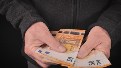 Un-Hombre-Recibe-Y-Cuenta-Billetes-De-Cincuenta-Euros-Con-Las-Manos