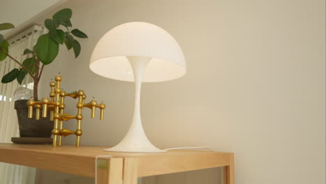 Moderner-Schreibtisch-Mit-Stilvoller-Lampe-Und-Goldener-Skulptur-In-Einem-Hellen-Raum