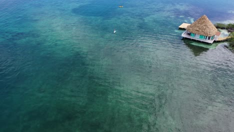 Immerse-yourself-in-the-tranquil-beauty-of-the-Caribbean-Sea-in-Belize,-showcasing-the-serene-art-of-paddleboarding-against-a-backdrop-of-azure-waters