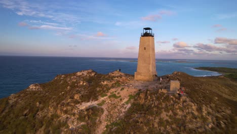 Küstenleuchtturm-Auf-Einem-Hügel-Mit-Meereshintergrund-Bei-Tageslicht,-Luftaufnahme