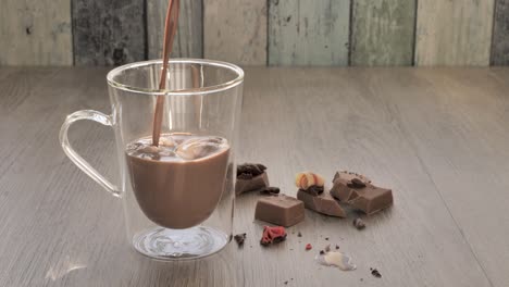Glas-Gefüllt-Mit-Schokoladenmilch-Auf-Holztisch-Mit-Schokoladenstücken