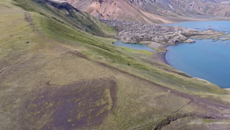Aerial-fixed-drone-view-from-bottom-to-top-of-lava-flow-falling-into-Frostastaðavatn-Lake-in-the-Landmannalaugar-region