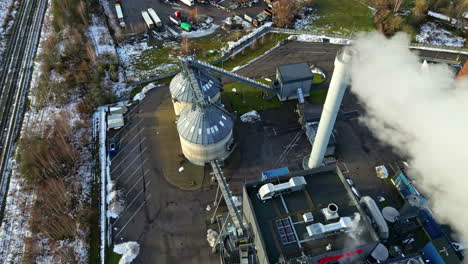 Aerial-panoramic-overview-of-smoke-exiting-smokestack-at-refinery-industrial-park